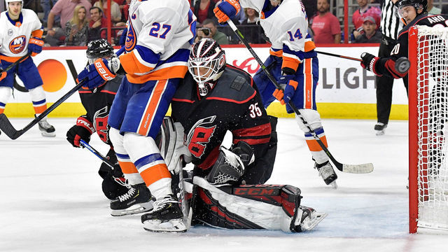 RALEIGH, NORTH CAROLINA - MAY 01: Curtis McElhinney #35 of the Carolina Hurricanes pushes Anders Lee #27 of the New York Islanders out of the crease during the third period of Game Three of the Eastern Conference Second Round during the 2019 NHL Stanley Cup Playoffs at PNC Arena on May 01, 2019 in Raleigh, North Carolina. The Hurricanes won 5-2.