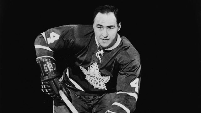 Publicity portrait of Canadian hockey player Red Kelly of the Toronto Maple Leafs as he skates up the ice with the puck, 1960s.
