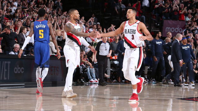 PORTLAND, OR - MAY 3: Damian Lillard #0 and CJ McCollum #3 of the Portland Trail Blazers high five against the Denver Nuggets during Game Three of the Western Conference SemiFinals of the 2019 NBA Playoffs on May 3, 2019 at the Moda Center Arena in Portland, Oregon. Mandatory Copyright Notice: Copyright 2019 NBAE