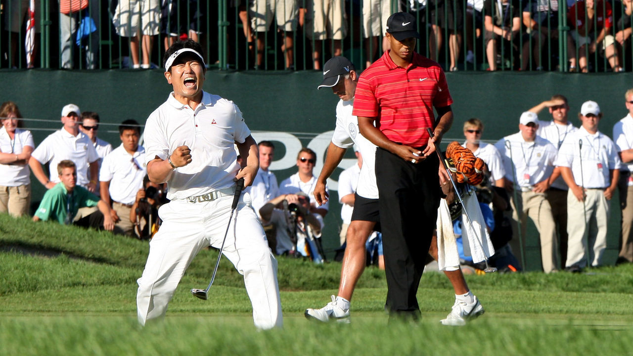 CHASKA, MN - AUGUST 16: (L-R) Y.E. Yang of South Korea celebrates a birdie putt on the 18th green alongside Tiger Woods during the final round of the 91st PGA Championship at Hazeltine National Golf Club on August 16, 2009 in Chaska, Minnesota.