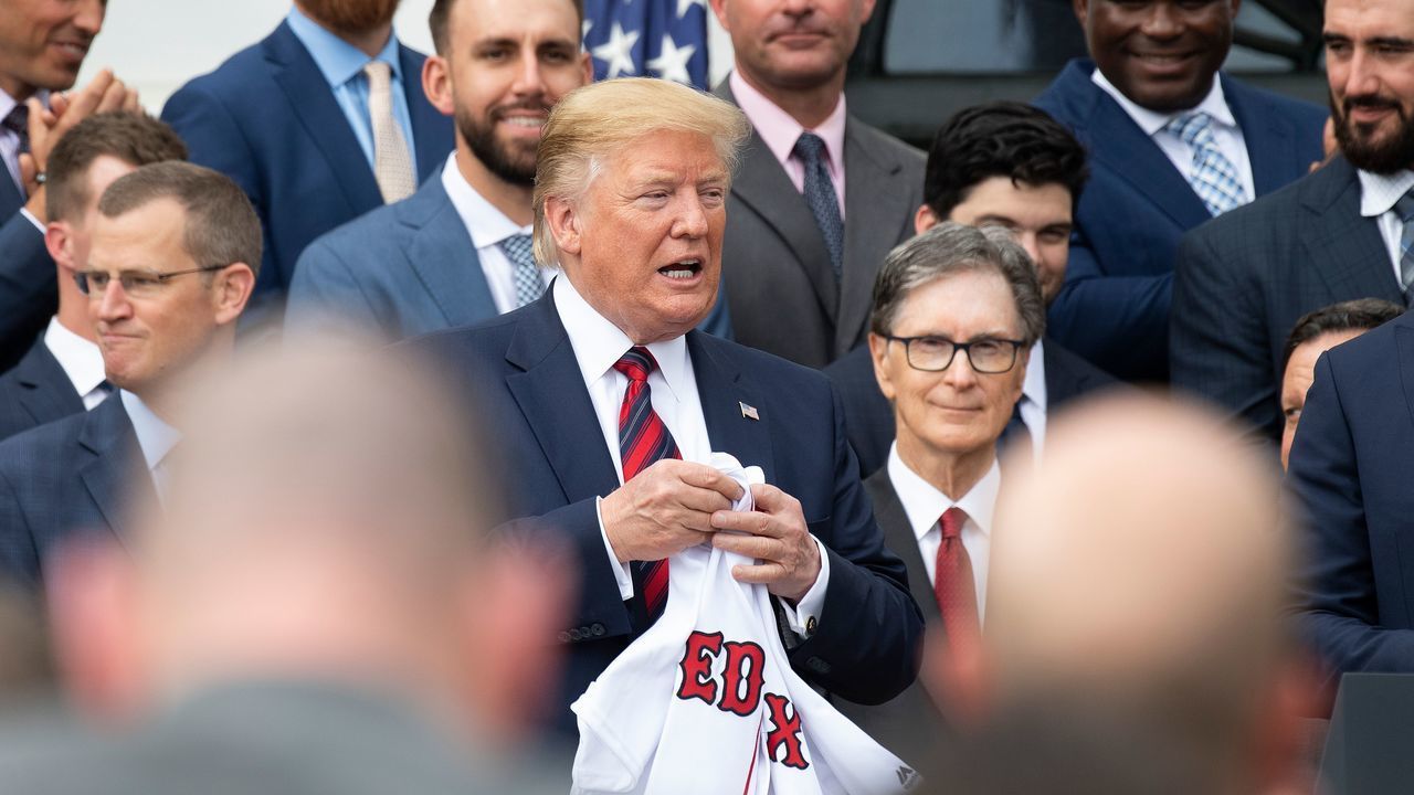US President Donald Trump (C) holds a Boston Redsox's jersey that was given to him as he welcomed the 2018 World Series Champions to the White House in Washington, DC, on May 9, 2019.
