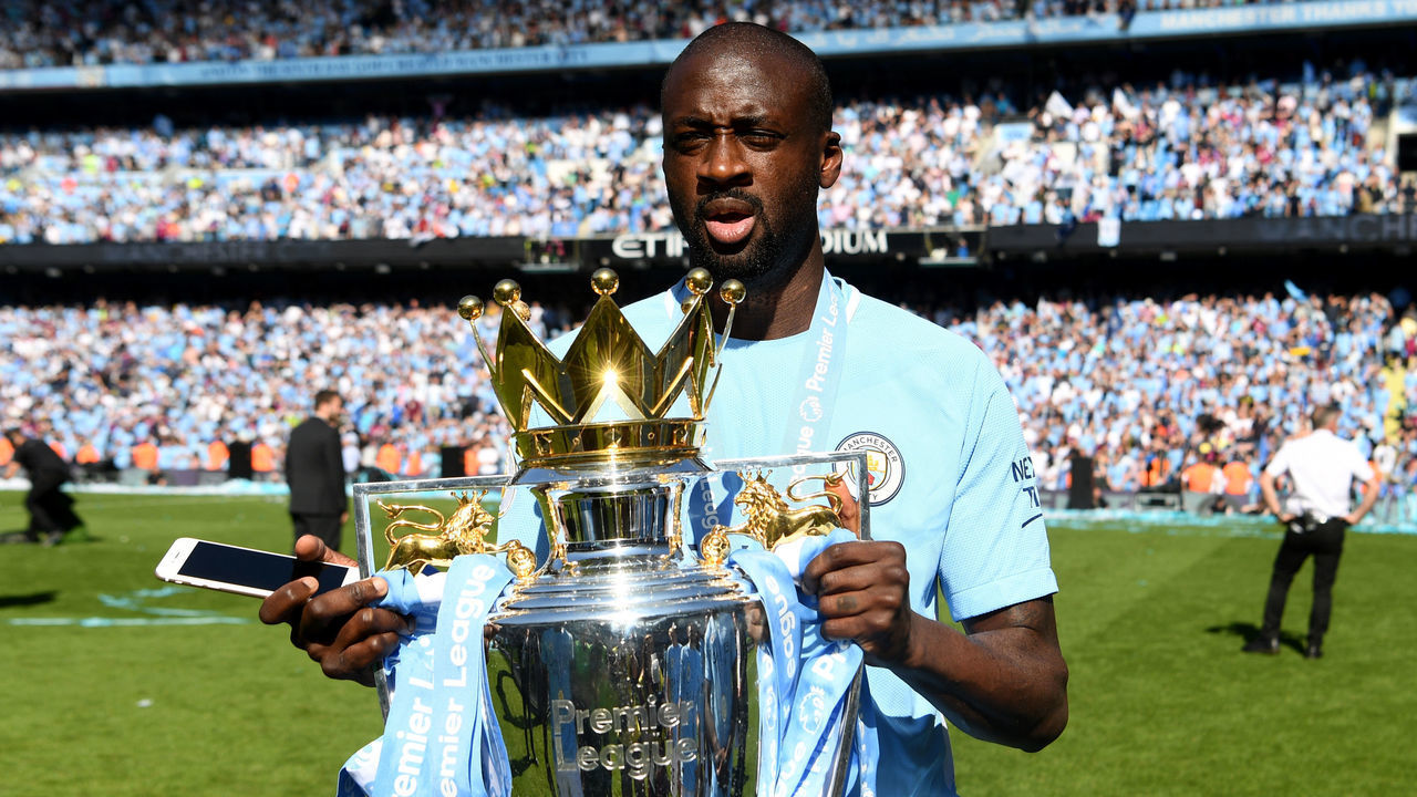 MANCHESTER, ENGLAND - MAY 06: Yaya Toure of Manchester City celebrates with The Premier League Trophy after the Premier League match between Manchester City and Huddersfield Town at Etihad Stadium on May 6, 2018 in Manchester, England.