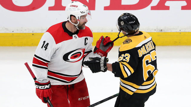 BOSTON, MASSACHUSETTS - MAY 12: Justin Williams #14 of the Carolina Hurricanes pulls on the chinstrap of Brad Marchand #63 of the Boston Bruins during the second period in Game Two of the Eastern Conference Final during the 2019 NHL Stanley Cup Playoffs at TD Garden on May 12, 2019 in Boston, Massachusetts.
