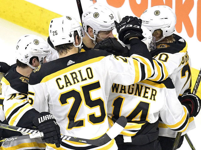 RALEIGH, NORTH CAROLINA - MAY 14: Chris Wagner #14 of the Boston Bruins celebrates with his teammates after scoring a goal on Curtis McElhinney #35 of the Carolina Hurricanes during the second period in Game Three of the Eastern Conference Finals during the 2019 NHL Stanley Cup Playoffs at PNC Arena on May 14, 2019 in Raleigh, North Carolina.