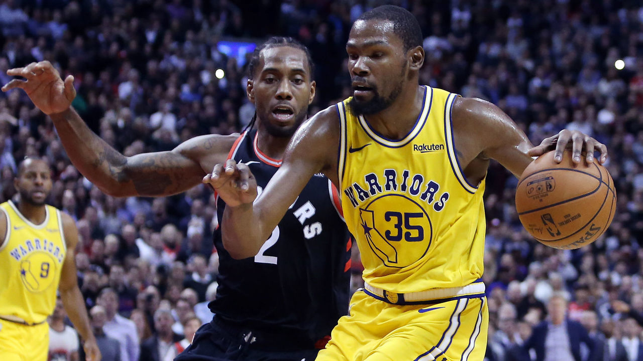 TORONTO, ON - NOVEMBER 29: Kevin Durant #35 of the Golden State Warriors dribbles the ball as Kawhi Leonard #2 of the Toronto Raptors defends during the second half of an NBA game at Scotiabank Arena on November 29, 2018 in Toronto, Canada.