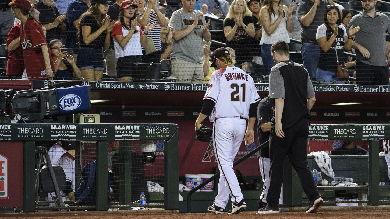 PHOENIX, ARIZONA - MAY 15: Zack Greinke #21 of the Arizona Diamondbacks leaves the game against the Pittsburgh Pirates in the eighth inning with head athletic trainer Ryan DiPanfilo at Chase Field on May 15, 2019 in Phoenix, Arizona.