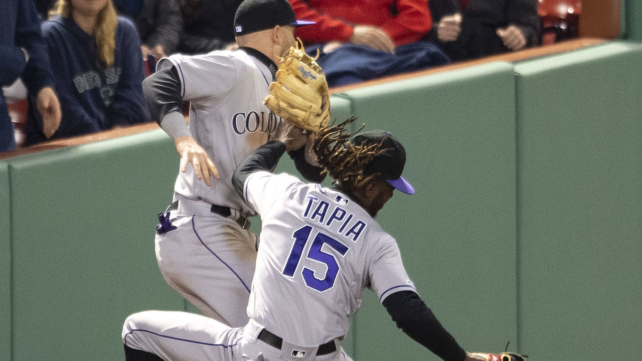 BOSTON, MA - MAY 15: Trevor Story #27 collides with Raimel Tapia #15 of the Colorado Rockies as they attempt to catch a fly ball hit by Mookie Betts #50 of the Boston Red Sox during the ninth inning of a game on May 15, 2019 at Fenway Park in Boston, Massachusetts.