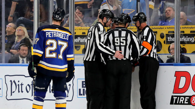 ST LOUIS, MISSOURI - MAY 15: Matt MacPherson #83, linesman Jonny Murray #95 and referee Dan O'Rourke #9 discuss a possible hand pass call between the San Jose Sharks and the St. Louis Blues in overtime in Game Three of the Western Conference Finals during the 2019 NHL Stanley Cup Playoffs at Enterprise Center on May 15, 2019 in St Louis, Missouri.