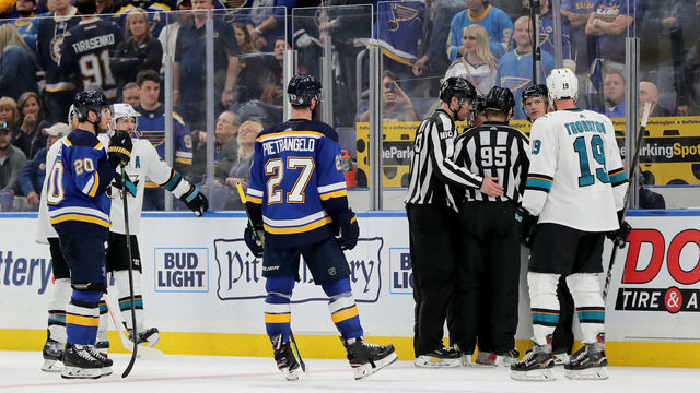 ST LOUIS, MISSOURI - MAY 15: Matt MacPherson #83, linesman Jonny Murray #95 and referee Dan O'Rourke #9 discuss a possible hand pass call between the San Jose Sharks and the St. Louis Blues in overtime in Game Three of the Western Conference Finals during the 2019 NHL Stanley Cup Playoffs at Enterprise Center on May 15, 2019 in St Louis, Missouri.