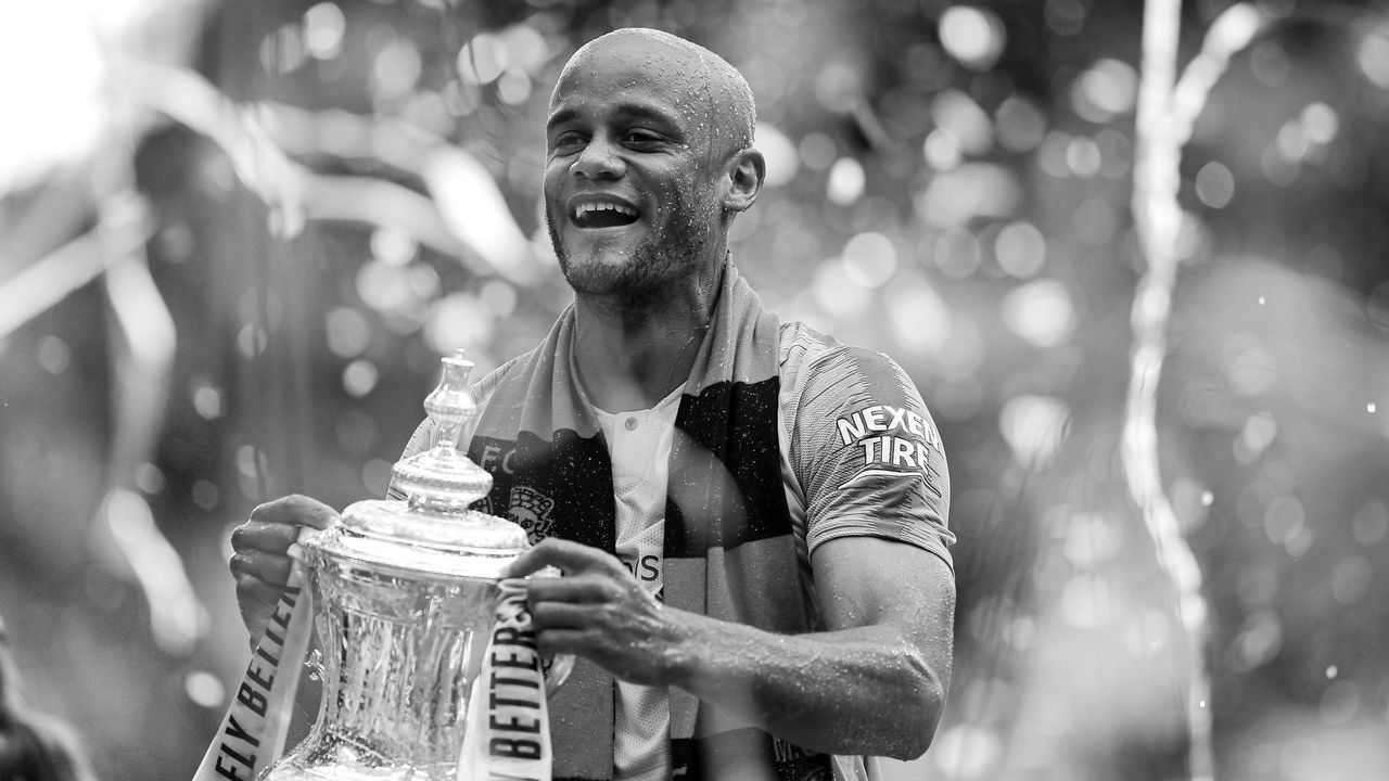 LONDON, ENGLAND - MAY 18: (EDITORS NOTE: THIS IMAGE HAS BEEN CONVERTED TO BLACK & WHITE) Vincent Kompany of Manchester City lifts the trophy following the FA Cup Final match between Manchester City and Watford at Wembley Stadium on May 18, 2019 in London, England.
