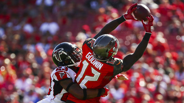 TAMPA, FL - DECEMBER 30: Wide receiver Chris Godwin #12 of the Tampa Bay Buccaneers is wrapped up by cornerback Robert Alford #23 of the Atlanta Falcons as he stretches for a pass from quarterback Jameis Winston #3 of the game at Raymond James Stadium on December 30, 2018 in Tampa, Florida.