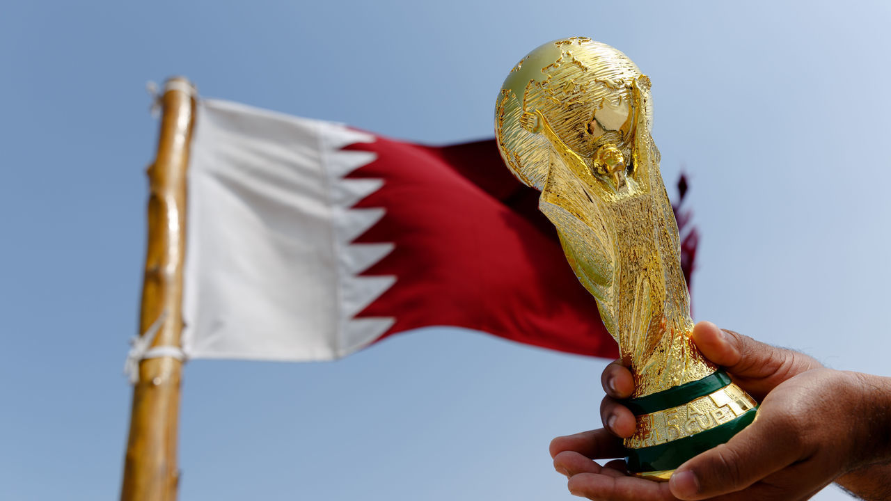 DOHA, QATAR - January 25 : A general view of a replica of the FIFA World Cup Trophy by the national flag of Qatar at the Al Zubara Fort, a UNESCO World Heritage Site, in Madinat ash Shamal, Qatar Al Zubara fort in the North of Qatar, the host country of the Qatar 2022 FIFA World Cup on January 25 2016 in Doha, Qatar.