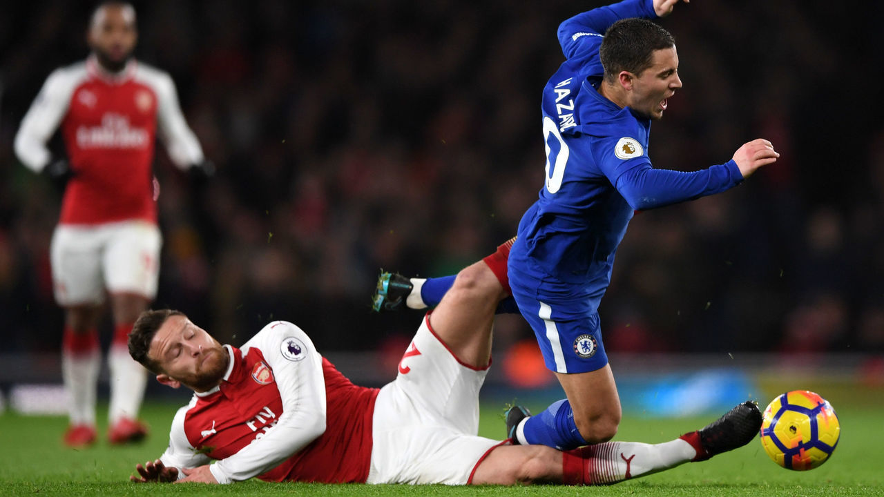LONDON, ENGLAND - JANUARY 03: Shkodran Mustafi of Arsenal tackles Eden Hazard during the Premier League match between Arsenal and Chelsea at Emirates Stadium on January 3, 2018 in London, England.