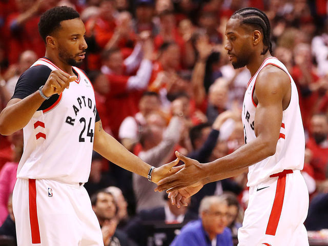 TORONTO, ONTARIO - MAY 21: Norman Powell #24 of the Toronto Raptors high fives Kawhi Leonard #2 during the second half against the Milwaukee Bucks in game four of the NBA Eastern Conference Finals at Scotiabank Arena on May 21, 2019 in Toronto, Canada.