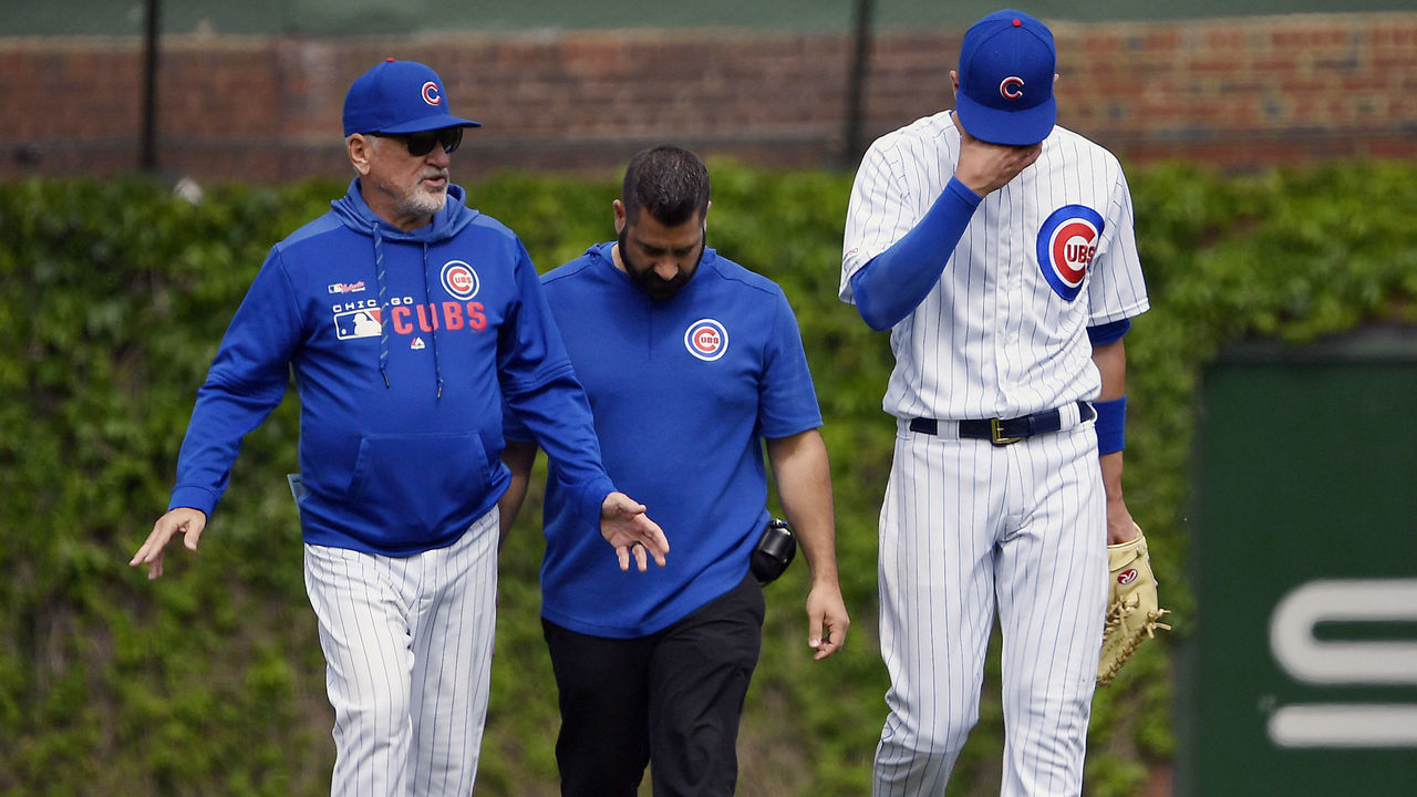 CHICAGO, ILLINOIS - MAY 26: Kris Bryant #17 of the Chicago Cubs reacts while leaving the game with Joe Maddon #70 of the Chicago Cubs and medical staff after colliding trying to catch a ball in the sixth inning against the Cincinnati Reds at Wrigley Field on May 26, 2019 in Chicago, Illinois.