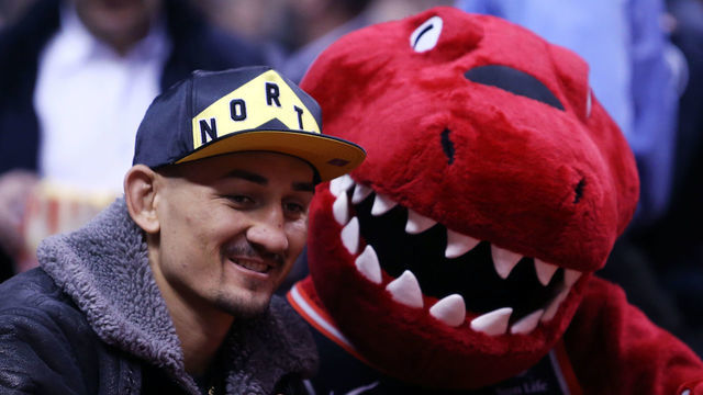 TORONTO, ON - DECEMBER 3: UFC fighter Max Holloway with the Toronto Raptors mascot, The Raptor prior to the first half of an NBA game against the Denver Nuggets at Scotiabank Arena on December 3, 2018 in Toronto, Canada.