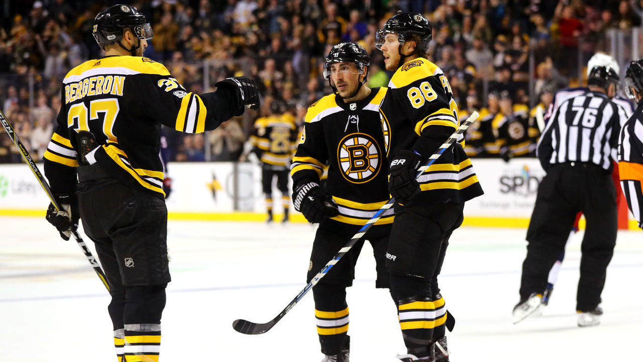 BOSTON, MA - DECEMBER 18: Patrice Bergeron #37 of the Boston Bruins celebrates with David Pastrnak #88 and Brad Marchand #63 after scoring a goal against the Columbus Blue Jackets during the third period at TD Garden on December 18, 2017 in Boston, Massachusetts. The Bruins defeat the Blued Jackets 7-2.