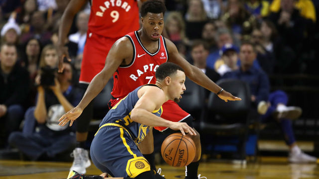 OAKLAND, CA - DECEMBER 12: Stephen Curry #30 of the Golden State Warriors dribbles on his knees while being guarded by Kyle Lowry #7 of the Toronto Raptors at ORACLE Arena on December 12, 2018 in Oakland, California.