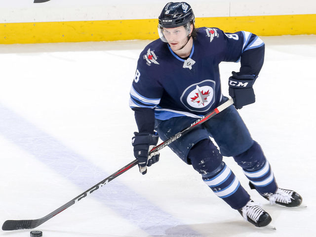 WINNIPEG, MB - MARCH 28: Jacob Trouba #8 of the Winnipeg Jets plays the puck up the ice during third period action against the New York Islanders at the Bell MTS Place on March 28, 2019 in Winnipeg, Manitoba, Canada. The Isles defeated the Jets 5-4.