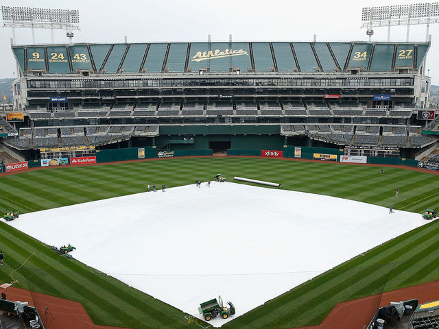 OAKLAND, CA - APRIL 16: A tarp covers the infield as rain falls before the game between the Houston Astros and the Oakland Athletics at Oakland Alameda Coliseum on April 16, 2017 in Oakland, California. The game was postponed to a future date do to the weather.