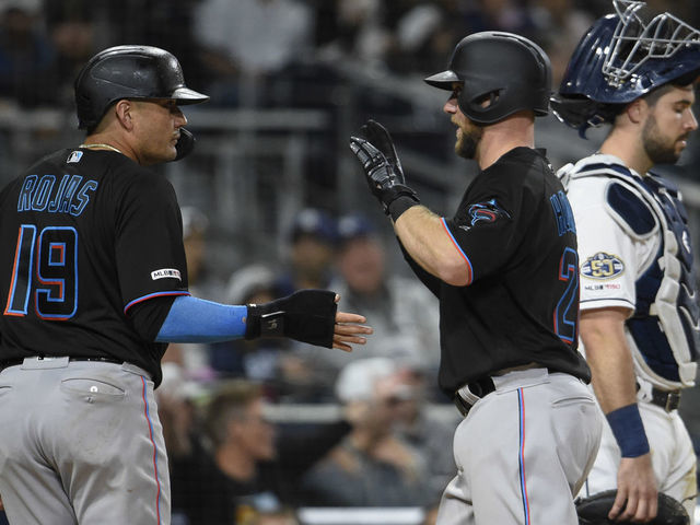 San Diego Padres' Garrett Cooper, right, celebrates with third