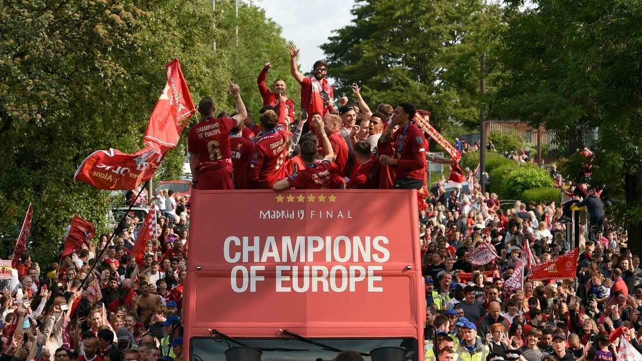 TOPSHOT - Liverpool's Brazilian goalkeeper Alisson Becker (C) stands and waves to the fans during an open-top bus parade around Liverpool, north-west England on June 2, 2019, after winning the UEFA Champions League final football match between Liverpool and Tottenham. - Liverpool's celebrations stretched long into the night after they became six-time European champions with goals from Mohamed Salah and Divock Origi to beat Tottenham -- and the party was set to move to England on Sunday where tens of thousands of fans awaited the team's return. The 2-0 win in the sweltering Metropolitano Stadium delivered a first trophy in seven years for Liverpool, and -- finally -- a first win in seven finals for coach Jurgen Klopp.