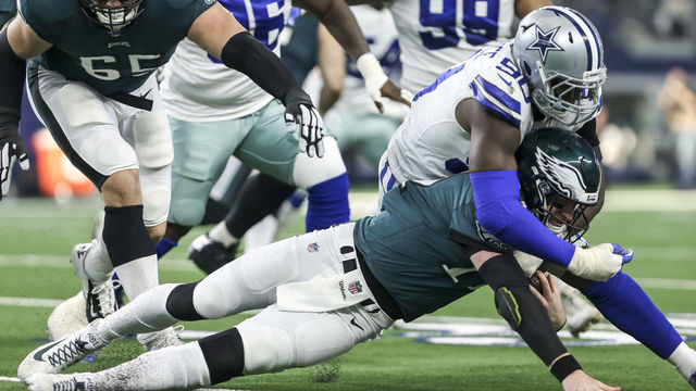 ARLINGTON, TX - DECEMBER 09: Philadelphia Eagles quarterback Carson Wentz (11) gets tackled by Dallas Cowboys defensive end Demarcus Lawrence (90) during the game between the Dallas Cowboys and the Philadelphia Eagles on December 9, 2018 at AT&T Stadium in Arlington. Texas.