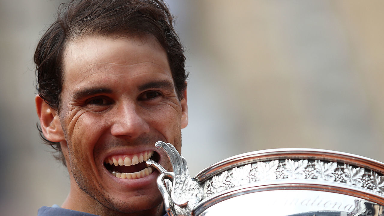 PARIS, FRANCE - JUNE 09: Rafael Nadal of Spain bites the trophy after defeating Dominic Thiem of Austria in the final during Day Fifteen of the 2019 French Open at Roland Garros on June 09, 2019 in Paris, France.