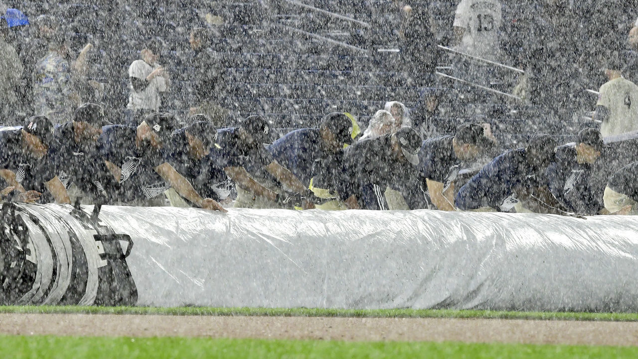 NEW YORK, NEW YORK - MAY 17: Grounds crew members roll out the tarp during a rain delay in the game between the New York Yankees and the Tampa Bay Rays at Yankee Stadium on May 17, 2019 in New York City.