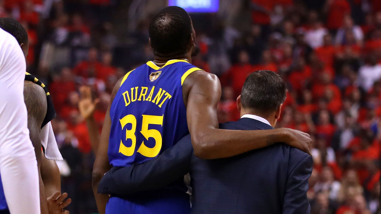 TORONTO, ONTARIO - JUNE 10: Kevin Durant #35 of the Golden State Warriors is assisted off the court after sustaining an injury in the first half against the Toronto Raptors during Game Five of the 2019 NBA Finals at Scotiabank Arena on June 10, 2019 in Toronto, Canada.