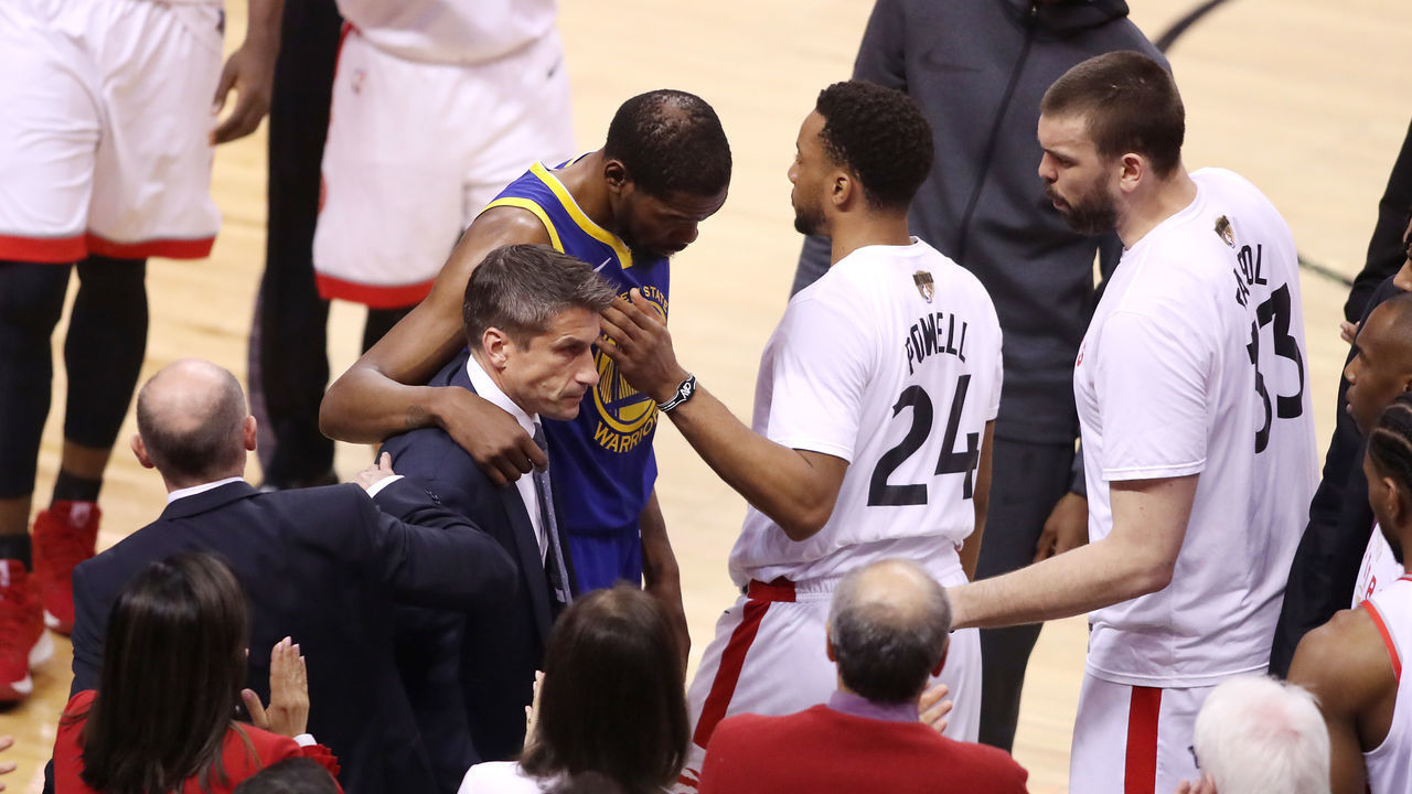 TORONTO, ONTARIO - JUNE 10: Kevin Durant #35 of the Golden State Warriors is assisted off the court after sustaining an injury in the first half against the Toronto Raptors during Game Five of the 2019 NBA Finals at Scotiabank Arena on June 10, 2019 in Toronto, Canada.