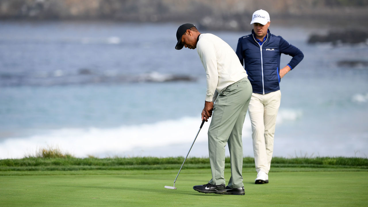 PEBBLE BEACH, CALIFORNIA - JUNE 12: Justin Thomas of the United States (R) looks on as Tiger Woods of the United States hits a putt on the tenth green during a practice round prior to the 2019 U.S. Open at Pebble Beach Golf Links on June 12, 2019 in Pebble Beach, California.