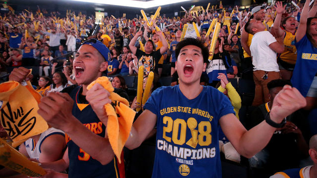OAKLAND, CA - JUNE 10: Golden State Warriors fans Wesley Chang, right, of Los Angeles, and Carlos Cardenas, of Monterey, cheer during an NBA Finals Game 5 watch party at Oracle Arena in Oakland, Calif., on Monday, June 10, 2019. The Warriors beat the Toronto Raptors 106-105 and will play Game 6 at the arena on Thursday.