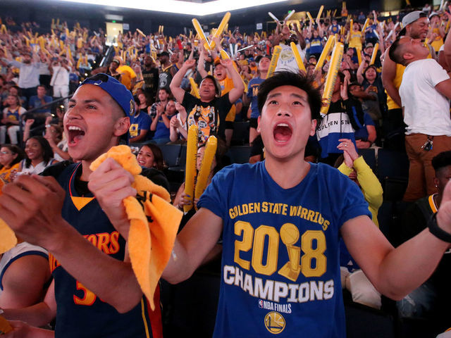 OAKLAND, CA - JUNE 10: Golden State Warriors fans Wesley Chang, right, of Los Angeles, and Carlos Cardenas, of Monterey, cheer during an NBA Finals Game 5 watch party at Oracle Arena in Oakland, Calif., on Monday, June 10, 2019. The Warriors beat the Toronto Raptors 106-105 and will play Game 6 at the arena on Thursday.