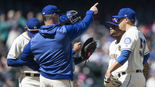 SEATTLE, WA - APRIL 28: Seattle Mariners manager Scott Servais (2L) signals to the bullpen as he pulls starting pitcher Erik Swanson #50 of the Seattle Mariners (R) during the fifth inning of a game against the Texas Rangers at T-Mobile Park on April 28, 2019 in Seattle, Washington. The Rangers won 14-1.