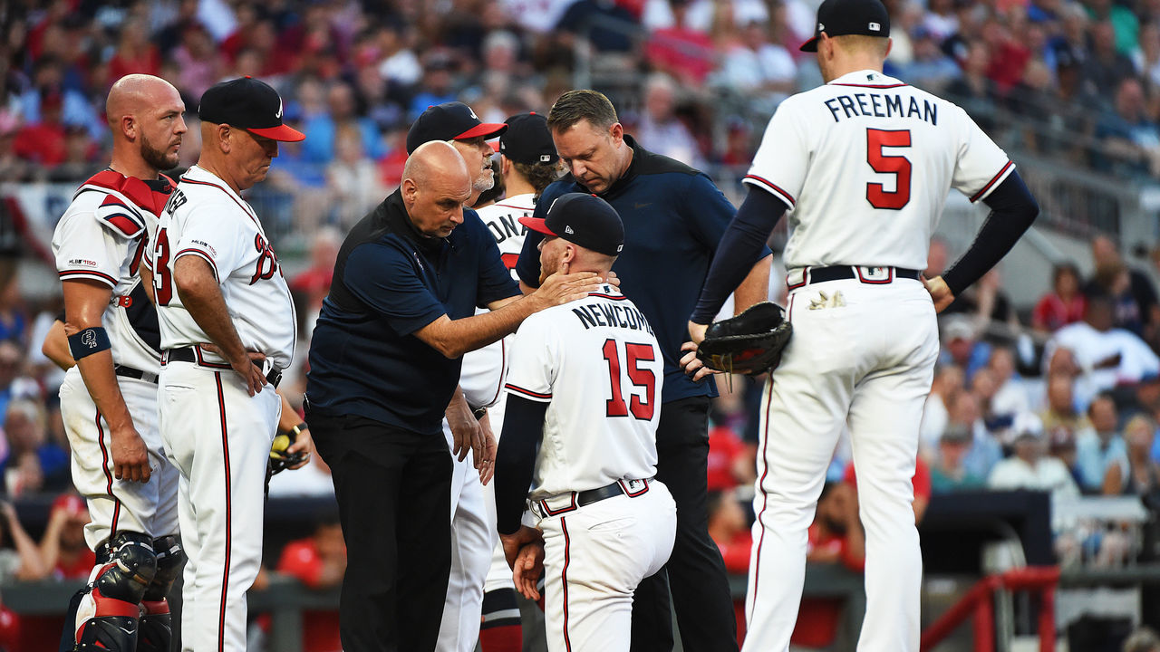 ATLANTA, GEORGIA - JUNE 15: Sean Newcomb #15 of the Atlanta Braves is attended to by training staff after being hit by a ball against the Philadelphia Phillies at SunTrust Park on June 15, 2019 in Atlanta, Georgia.