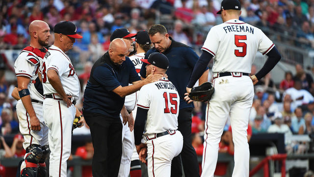 ATLANTA, GEORGIA - JUNE 15: Sean Newcomb #15 of the Atlanta Braves is attended to by training staff after being hit by a ball against the Philadelphia Phillies at SunTrust Park on June 15, 2019 in Atlanta, Georgia.