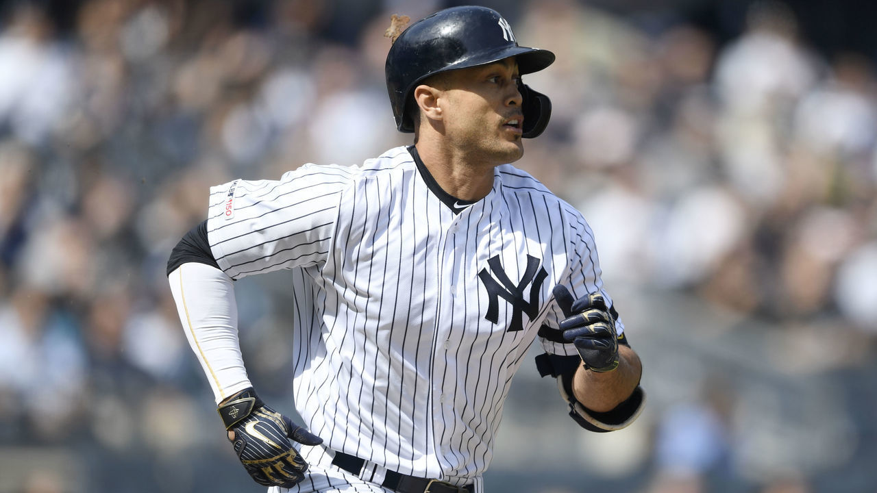 NEW YORK, NEW YORK - MARCH 30: Giancarlo Stanton #27 of the New York Yankees watches a fly ball while running to first during the third inning of the game against the Baltimore Orioles at Yankee Stadium on March 30, 2019 in the Bronx borough of New York City.