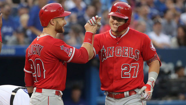 TORONTO, ON - JUNE 19: Mike Trout #27 of the Los Angeles Angels of Anaheim is congratulated by Jonathan Lucroy #20 after hitting a grand slam home run in the fourth inning during MLB game action against the Toronto Blue Jays at Rogers Centre on June 19, 2019 in Toronto, Canada.