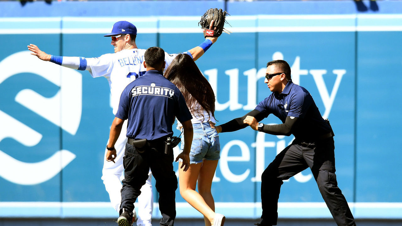 LOS ANGELES, CALIFORNIA - JUNE 23: Cody Bellinger #35 of the Los Angeles Dodgers reacts as a fan chases after him on the field during the ninth inning against the Colorado Rockies at Dodger Stadium on June 23, 2019 in Los Angeles, California.