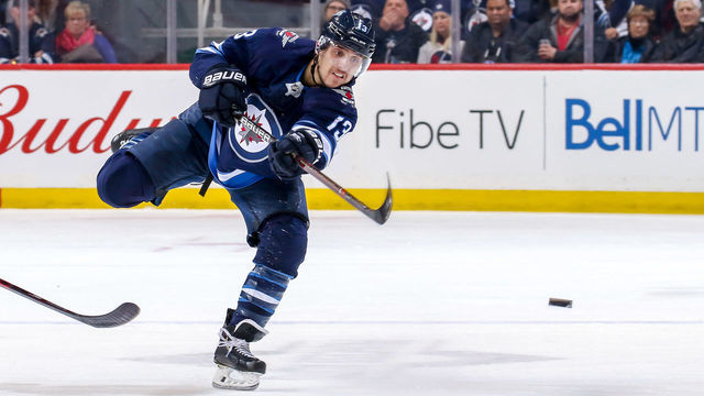 WINNIPEG, MB - MARCH 28: Brandon Tanev #13 of the Winnipeg Jets shoots the puck down the ice during second period action against the New York Islanders at the Bell MTS Place on March 28, 2019 in Winnipeg, Manitoba, Canada.