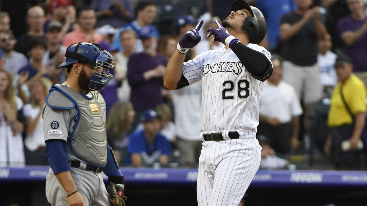 DENVER, CO - JUNE 28: Colorado Rockies third baseman Nolan Arenado (28) points to the sky after hitting a two-run home run against Los Angeles Dodgers starting pitcher Hyun-Jin Ryu (99) in the first inning scoring Charlie Blackmon at Coors Field June 28, 2019. Los Angeles Dodgers catcher Russell Martin (55) watches as Arenado crosses home plate.