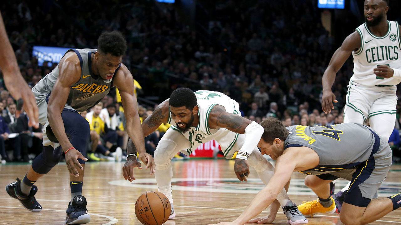 BOSTON - MARCH 29: Boston Celtics' Kyrie Irving, center, battles for a loose ball with Indiana Pacers' Thaddeus Young, left, and Bojan Bogdanovic during the fourth quarter. The Boston Celtics host the Indiana Pacers in a regular season NBA basketball game at TD Garden in Boston on March 29, 2019.