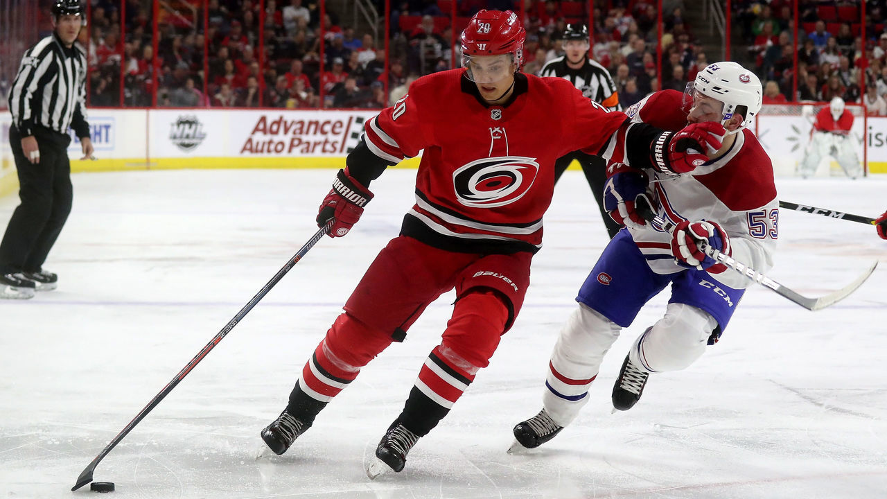 RALEIGH, NC - MARCH 24: Sebastian Aho #20 of the Carolina Hurricanes controls the puck away from Victor Mete #53 of the Montreal Canadiens during an NHL game on March 24, 2019 at PNC Arena in Raleigh, North Carolina.