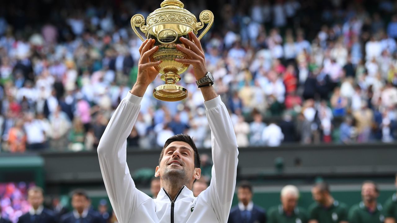Serbia's Novak Djokovic raises the winner's trophy after beating Switzerland's Roger Federer during their men's singles final on day thirteen of the 2019 Wimbledon Championships at The All England Lawn Tennis Club in Wimbledon, southwest London, on July 14, 2019.