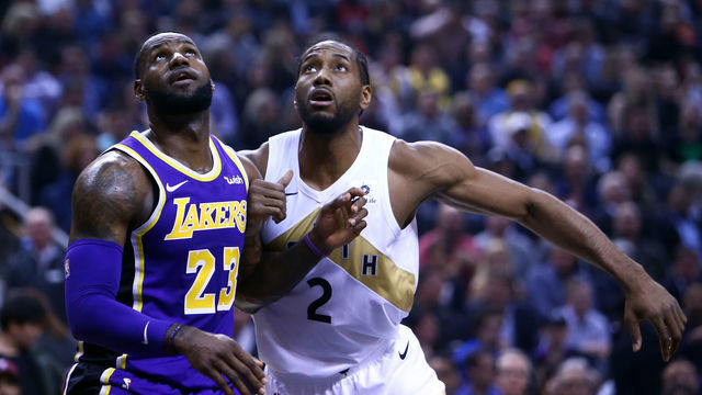 TORONTO, ON - MARCH 14: LeBron James #23 of the Los Angeles Lakers battles for space with Kawhi Leonard #2 of the Toronto Raptors during the first half of an NBA game at Scotiabank Arena on March 14, 2019 in Toronto, Canada.