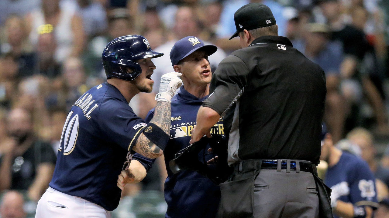 MILWAUKEE, WISCONSIN - JULY 15: Yasmani Grandal #10 and manager Craig Counsell argue with umpire Jordan Baker after Grandal was ejected in the fifth inning against the Atlanta Braves at Miller Park on July 15, 2019 in Milwaukee, Wisconsin.