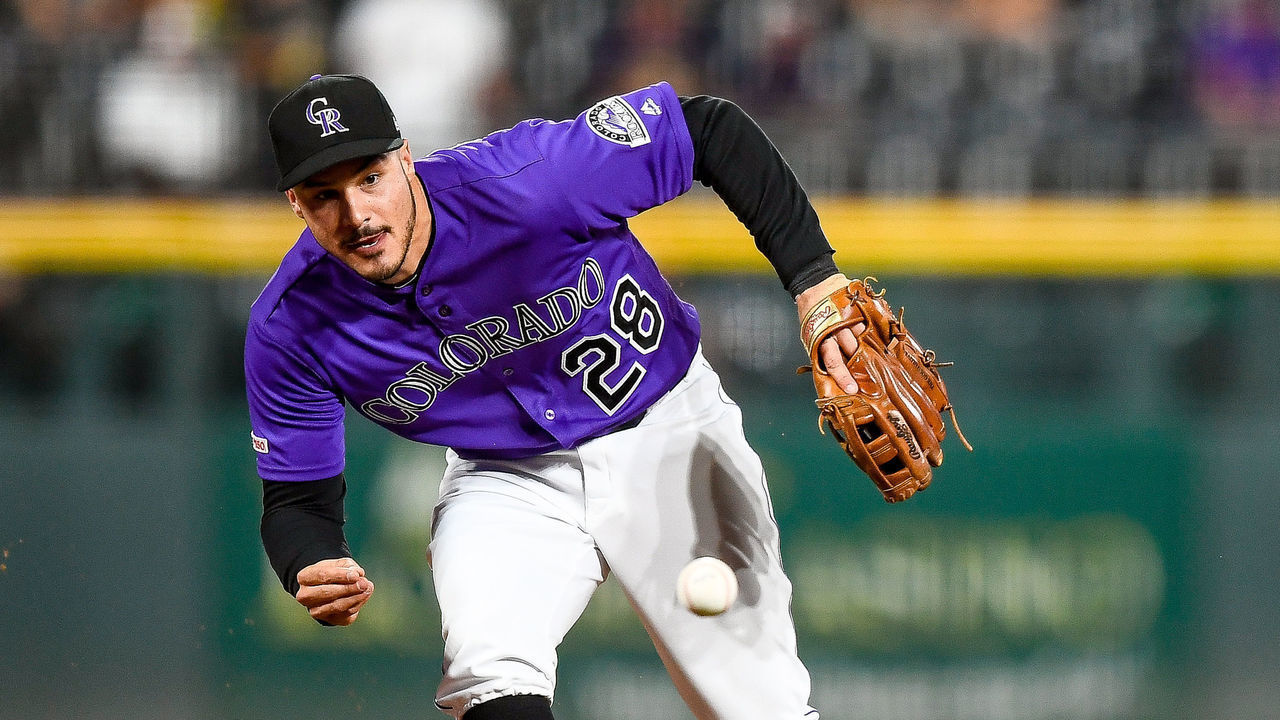 DENVER, CO - JULY 13: Nolan Arenado #28 of the Colorado Rockies reaches to make a barehanded defensive play in the first inning of a game against the Cincinnati Reds at Coors Field on July 13, 2019 in Denver, Colorado.