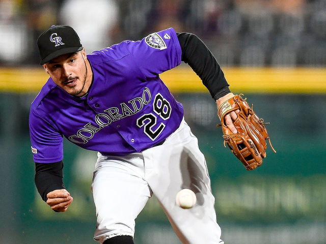 DENVER, CO - JULY 13: Nolan Arenado #28 of the Colorado Rockies reaches to make a barehanded defensive play in the first inning of a game against the Cincinnati Reds at Coors Field on July 13, 2019 in Denver, Colorado.