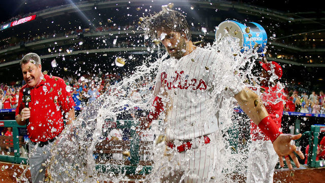 PHILADELPHIA, PA - JULY 16: Bryce Harper #3 of the Philadelphia Phillies is doused with water by teammate Jean Segura #2 after hitting a walk-off two run double in the ninth inning to defeat the Los Angeles Dodgers 9-8 in a baseball game at Citizens Bank Park on July 16, 2019 in Philadelphia, Pennsylvania.